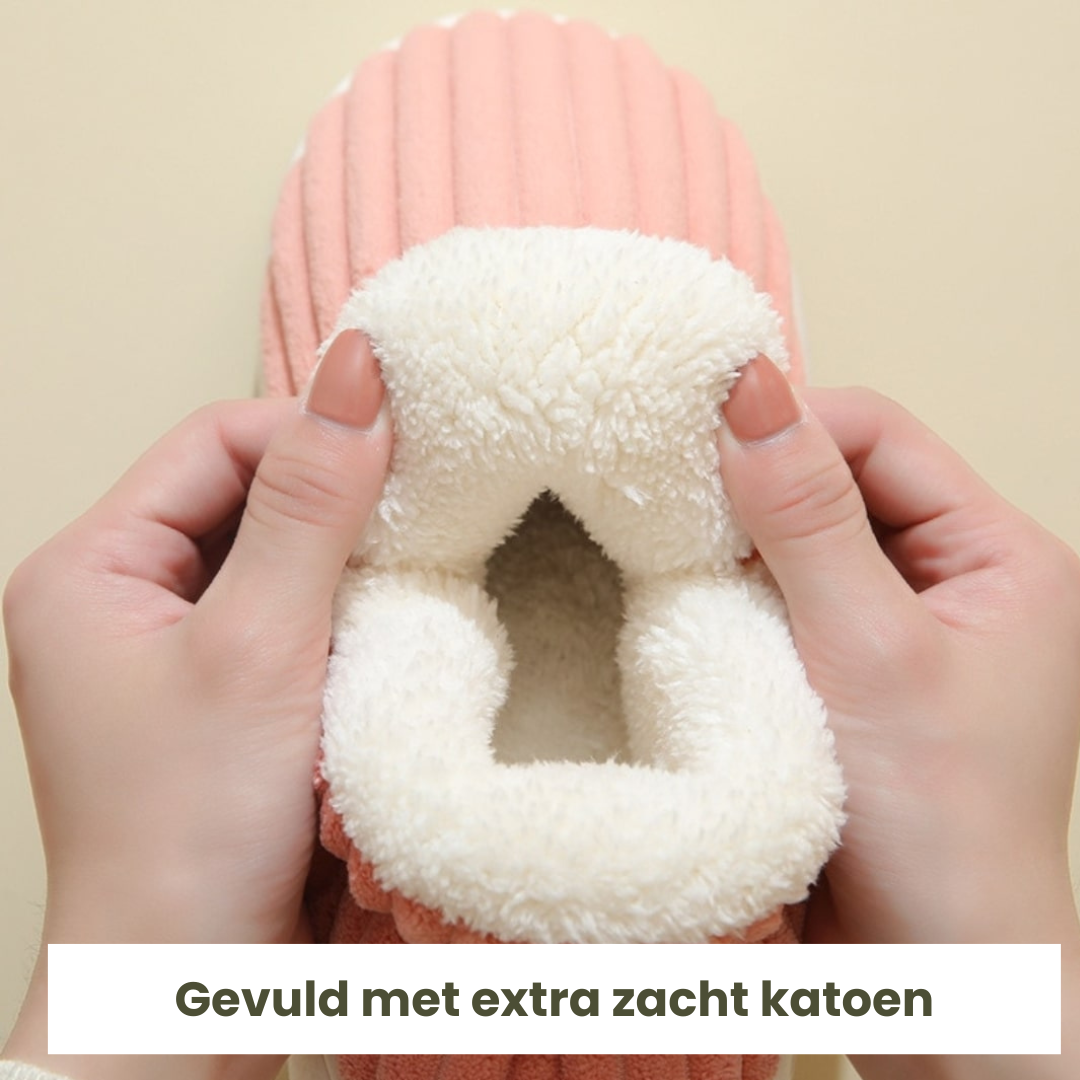 Close-up van handen die een zachte witte binnenkant van een roze pantoffel tonen.