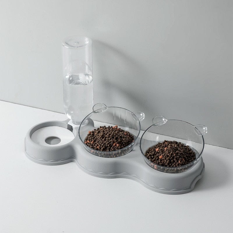 Grijze voedertray met waterdispenser en voerbakken.