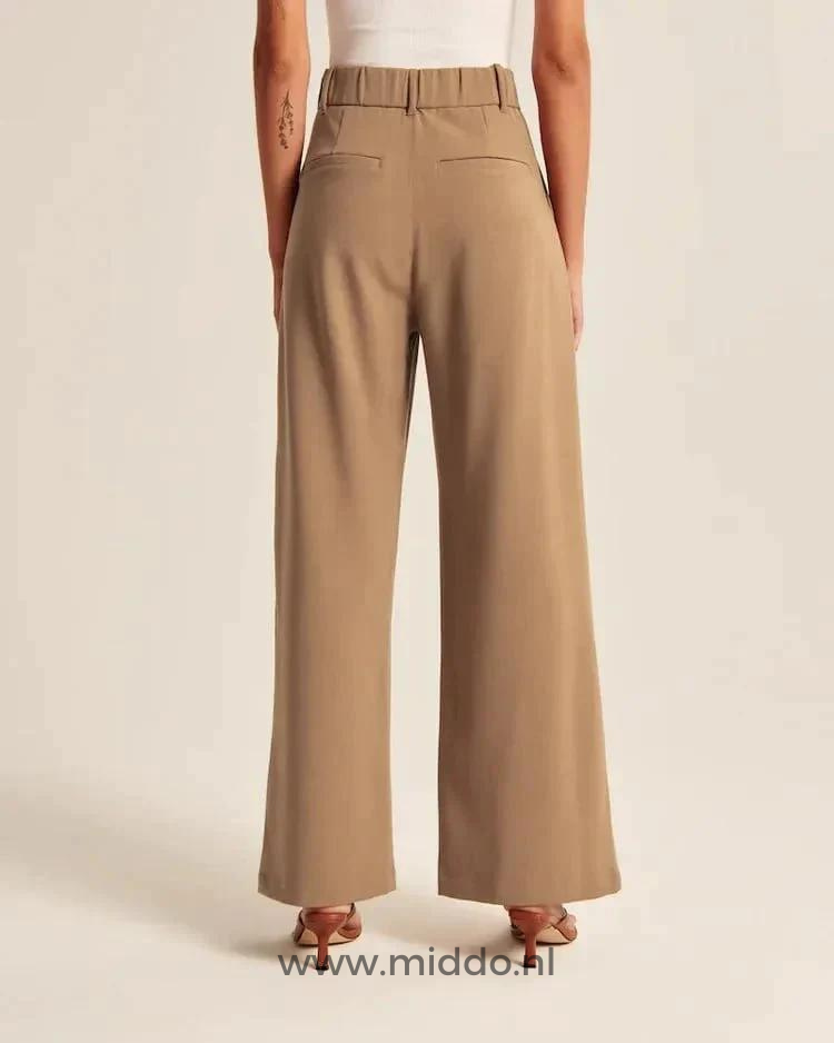 Deze dame showt de achterkant van de bruine Wijdepantalon met 2 achterzakken.