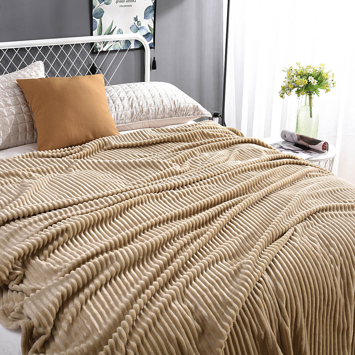 Beige fluwelen fleece kleed op een bed met kussen en bloemenvaas