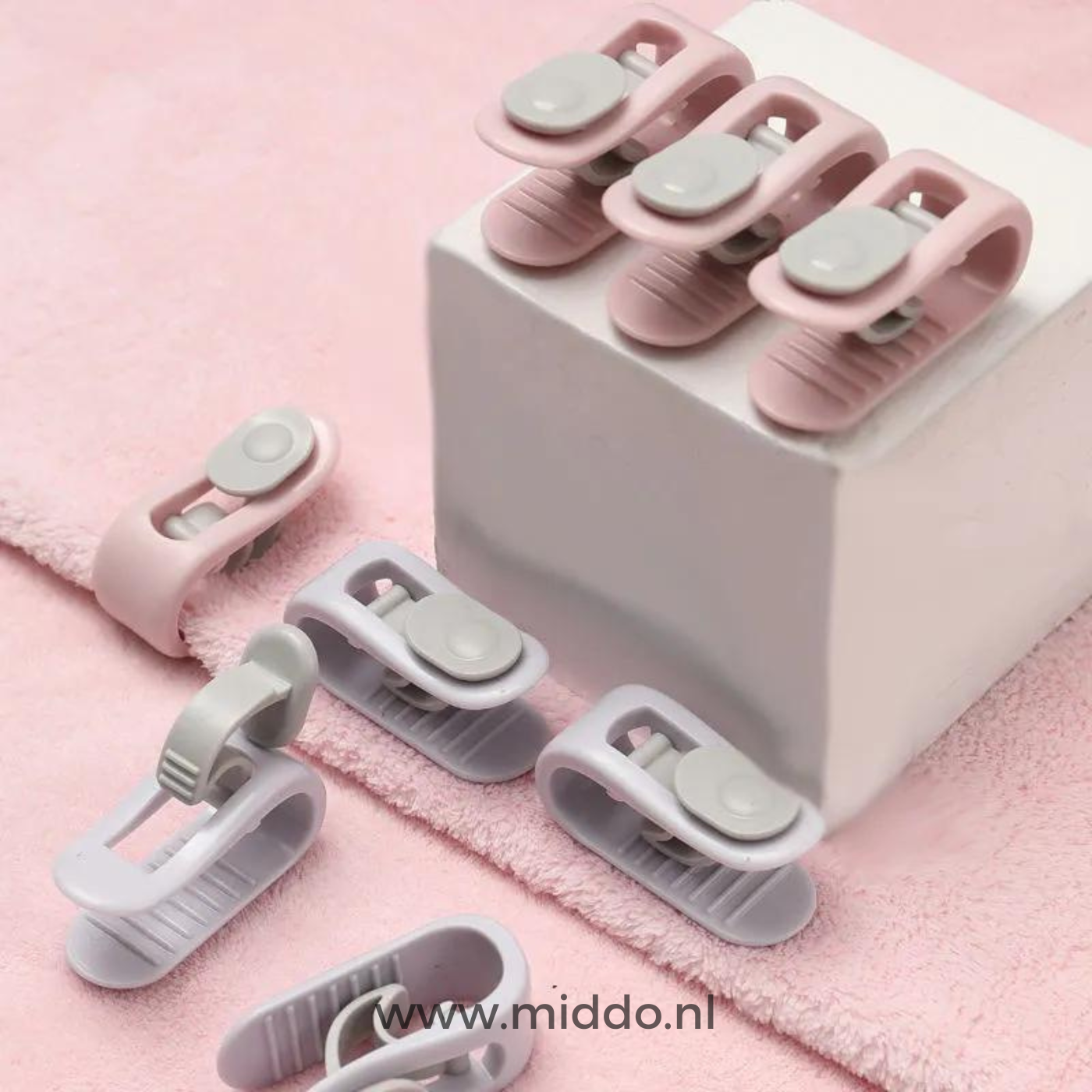 Verschillende kleuren dekbedklemmen op roze handdoek