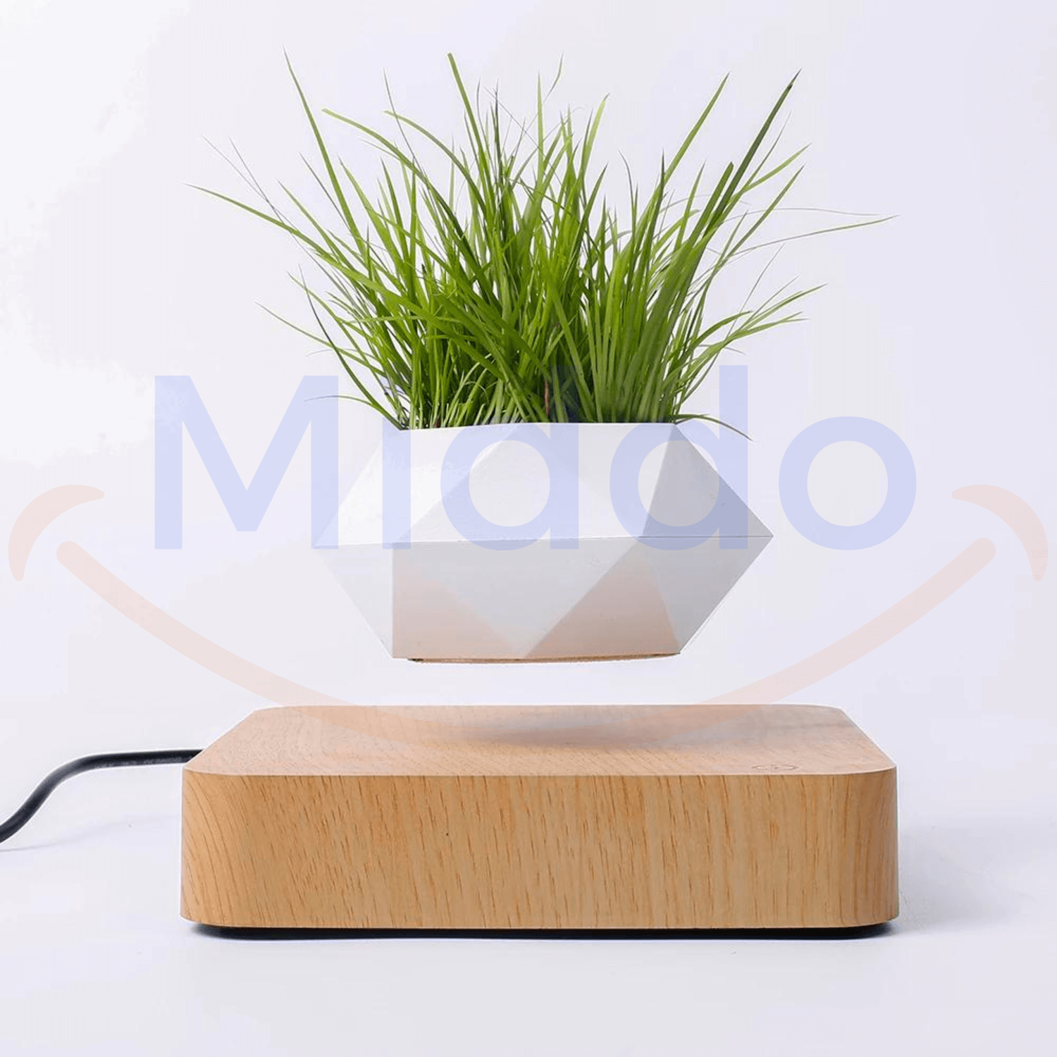 Witte zwevende pot met groen gras op lichtbruine basis.