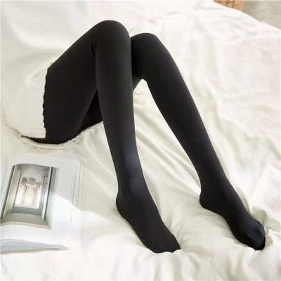 Zwarte panty met gesloten tenen, dame zit op bed.