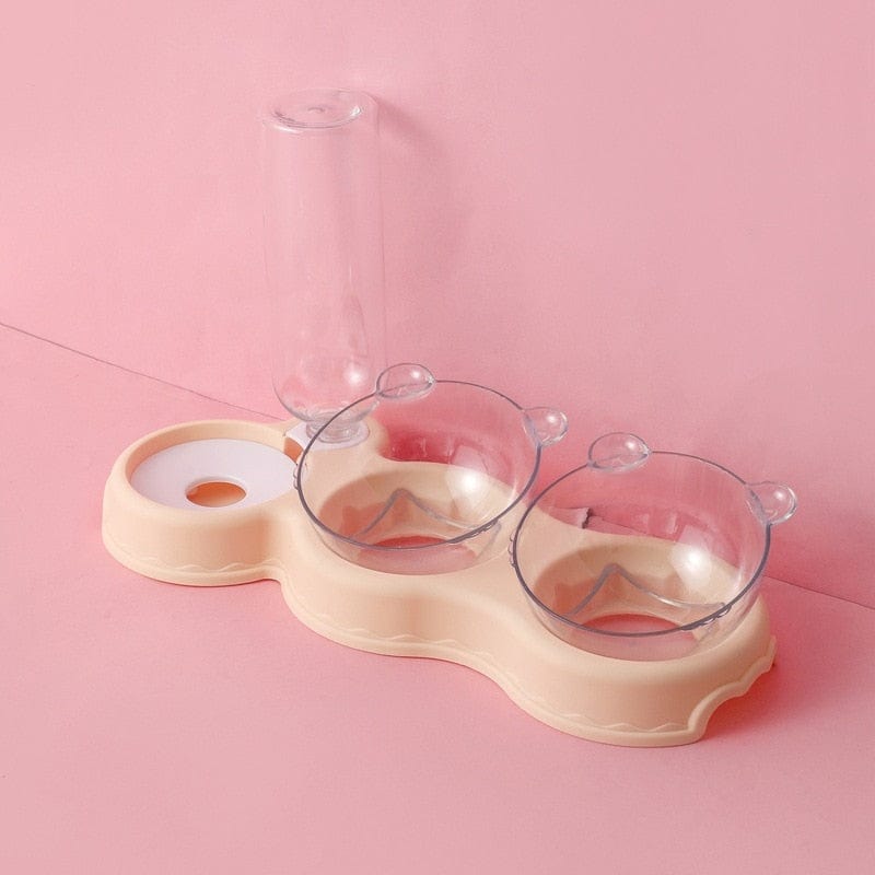 Lege beige voederbak en waterfles op roze achtergrond.